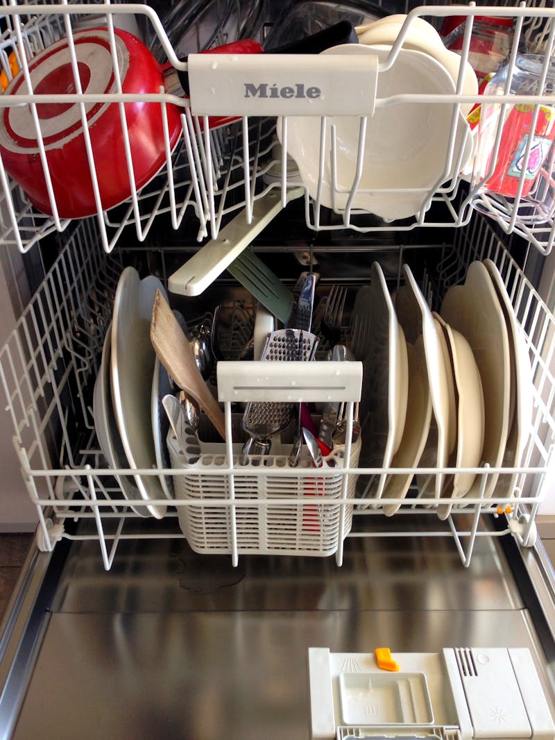Open dishwasher loaded with dishes ready for cleaning