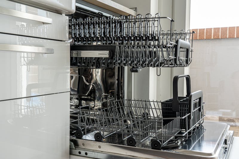 Open dishwasher showing empty racks and filter area